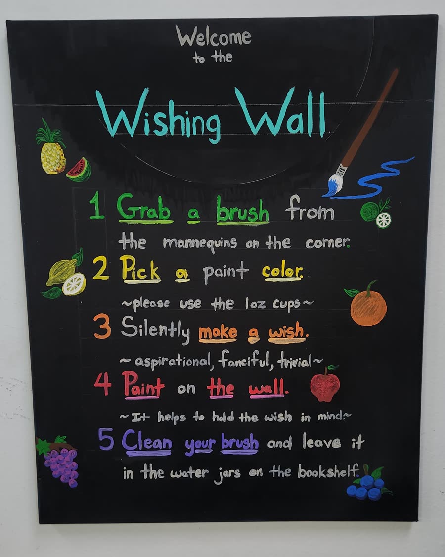 The hand-painted Wishing Wall sign at Swami Juice, listing the five steps in coloured lettering with fruit painted in the margins